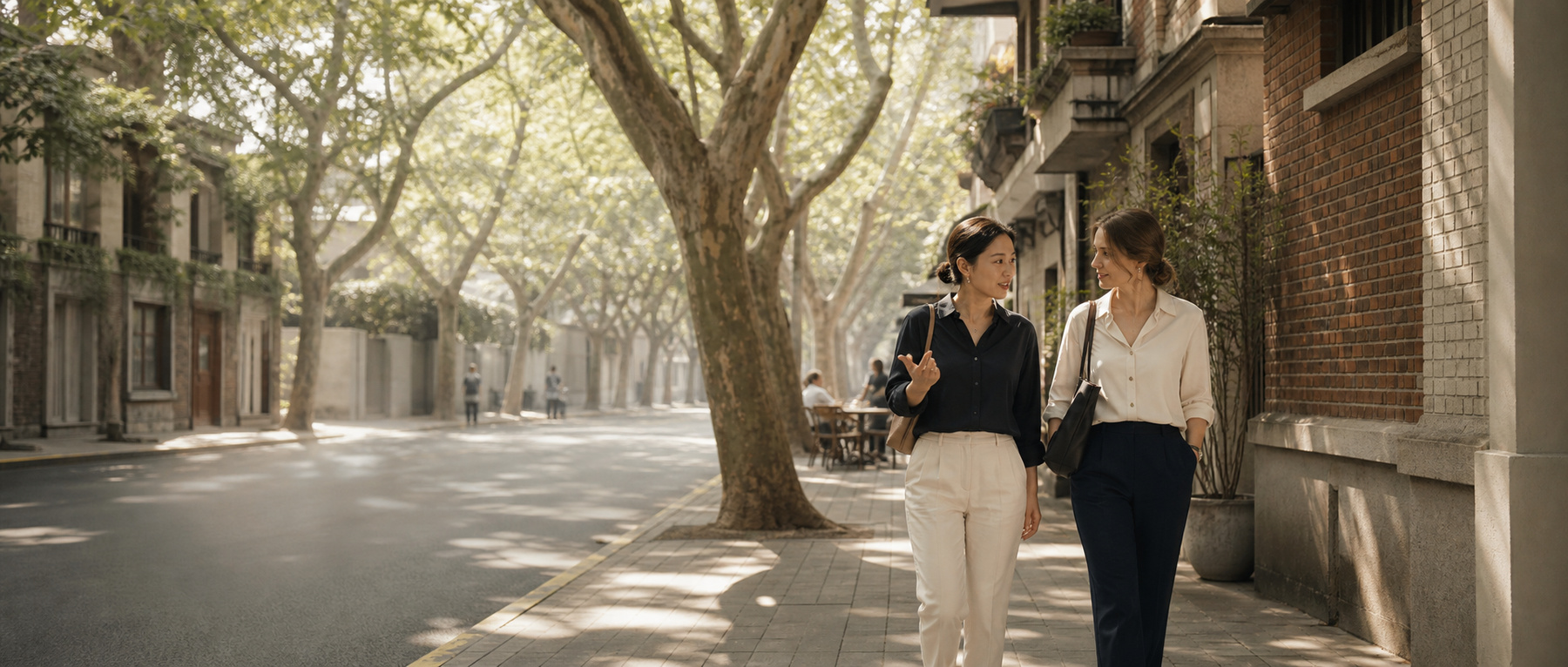 Two people sharing a conversation on a tree-lined Shanghai street